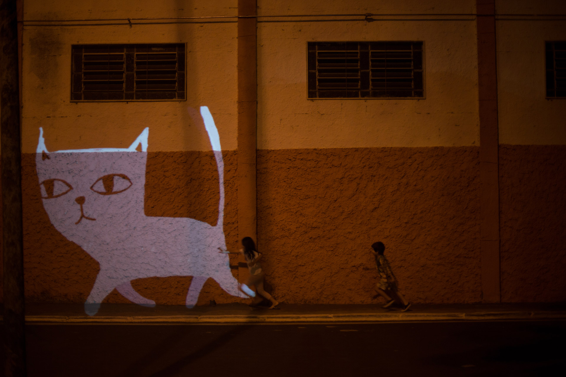 VJ Suave Suaveciclo conducting mobile projection mapping of a white cat animated character