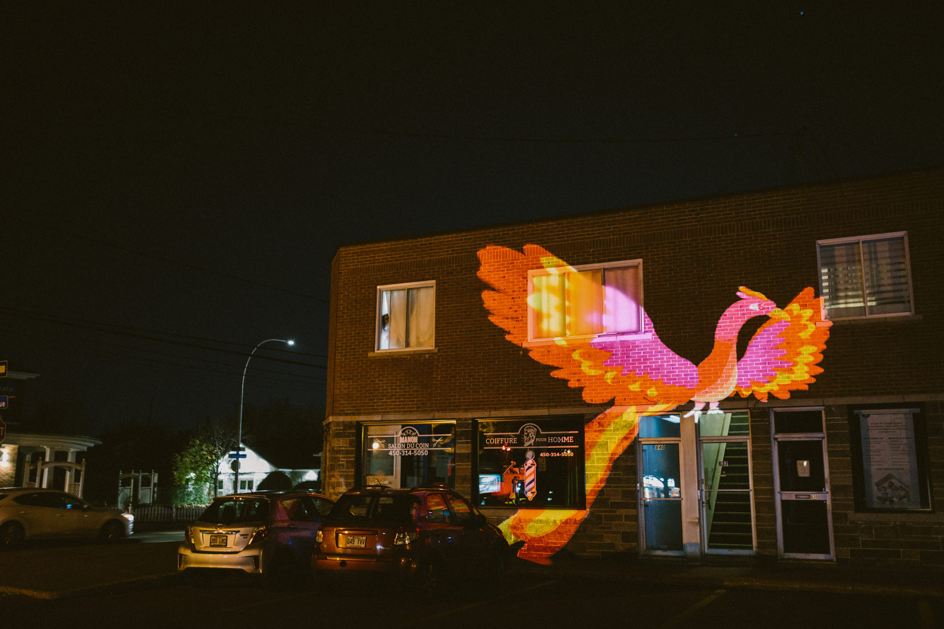 VJ Suave mapping projections of a red phoenix on a city wall