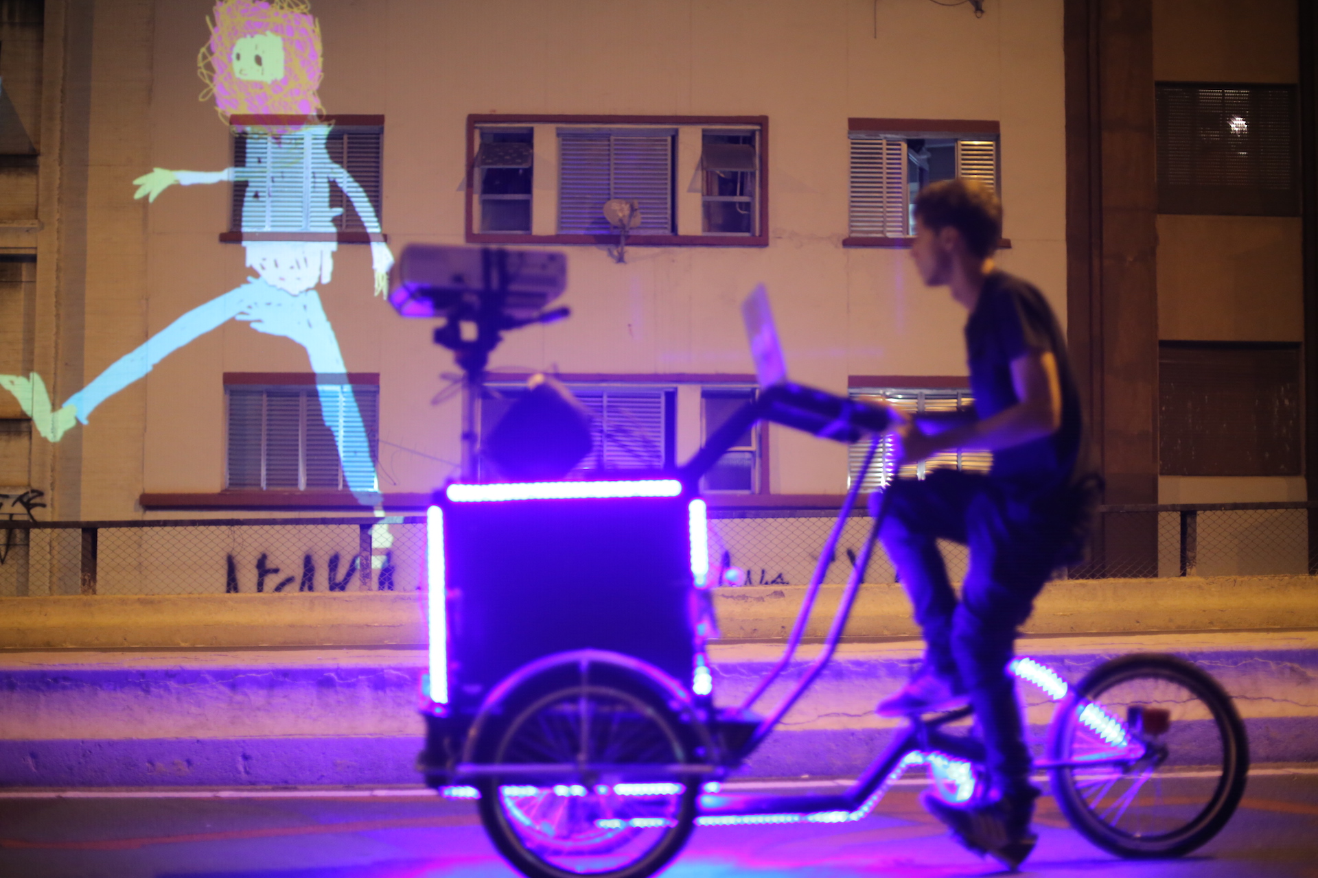 VJ Suave Suaveciclo conducting mobile projection mapping on a city wall